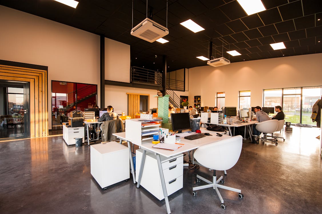 Modern open office space with desks and workers