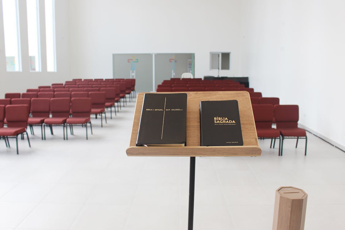 Modern church interior with rows of padded chairs and Bible on lectern